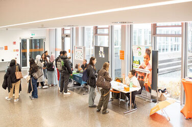 Interessierte Besucher*innen in regem Austausch an den Informationsständen des International Day am Standort Sonnenstraße. Interested visitors engaged in lively dialogue at the International Day exhibition stands on campus Sonnenstraße