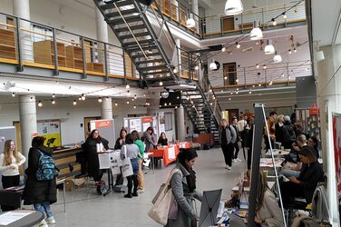 Übersicht über das Foyer des Fachbereichs Architekur der Fachhochschule Dortmund mit Ausstellerständen des international Day. Studierende informieren sich an den Ständen zu Fragen rund um den Auslandsaufenthalt. Overview of the foyer of the Faculty of Architecture at Dortmund University of Applied Sciences and Arts with exhibitor stands at the International Day. Students inform themselves about questions concerning their stay abroad.