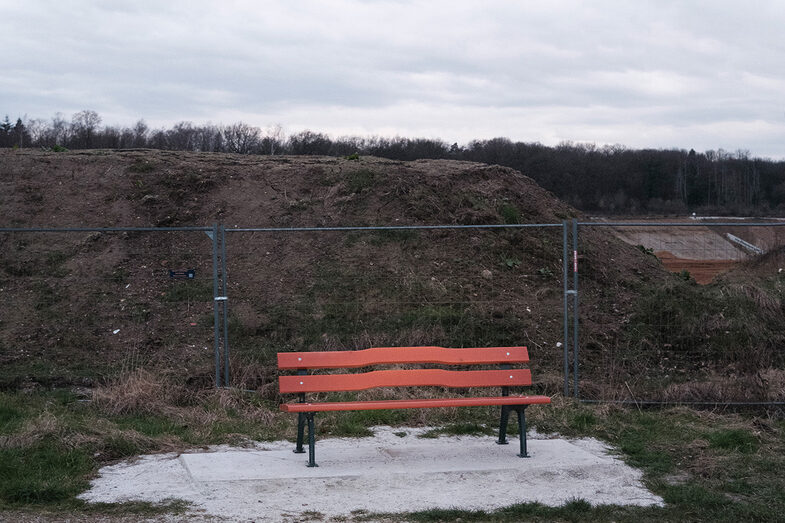 Bench in front of a construction site fence