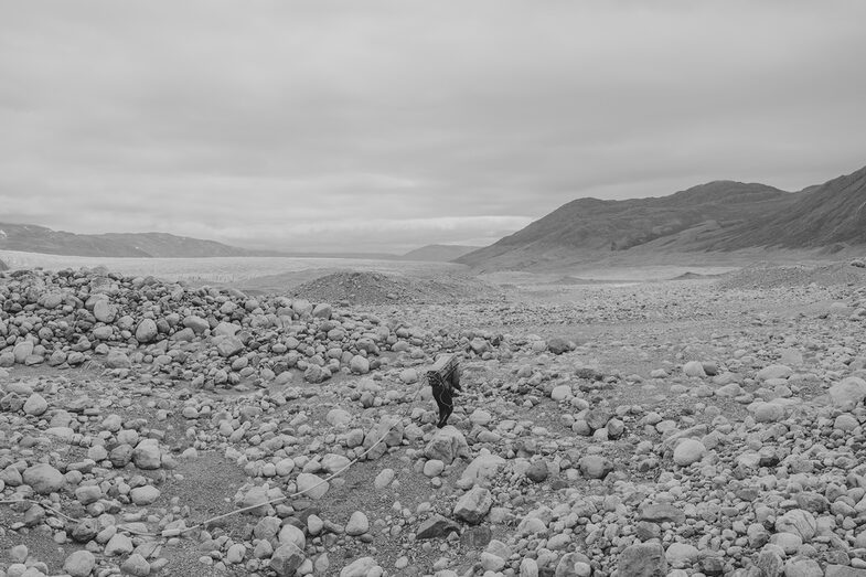 Black and white. Person on a field with stones.