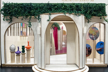 View of and through the entrance door and shop window of a model of a funeral home.