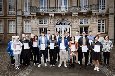 Winner of the 12th Schlaun Competition 2023|2024 in front of the historic Erbdrostenhof building in Münster.