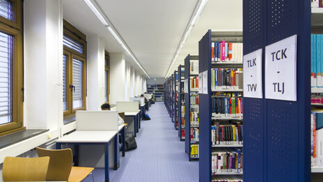 Photo of rows of bookshelves and individual desks in the library__Photo of library book shelves and desks
