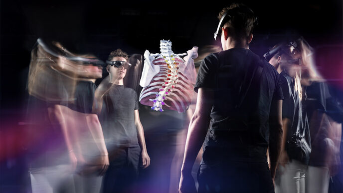 A group of young people standing in a circle look at the hologram of a human torso skeleton through virtual reality glasses.