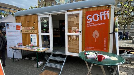 A converted construction trailer, which now serves as a mobile sustainability office, stands in a square for the exhibition.