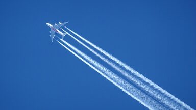 An airplane and its contrails can be seen in the sky.