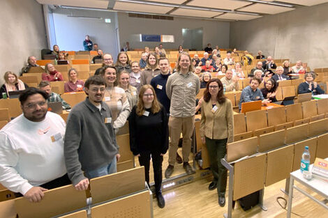 Eine Gruppe steht in einem Hörsaal