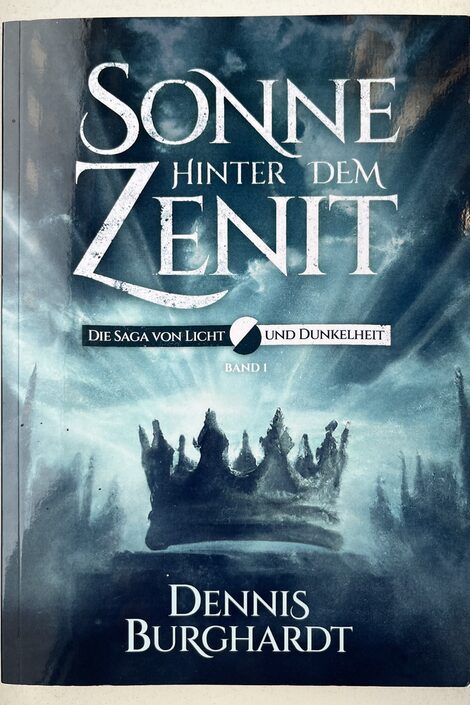 The cover of a book entitled "Sun behind the zenith" shows a crown on a rock in front of a wooded hilly landscape.