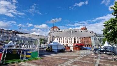 Tents, barriers and a small soccer goal are set up on a large square in front of the old Dortmund town hall.