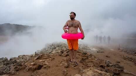 The picture shows a member of the MSG collective in a natural pool in Iceland. The picture is staged, among other things with a pink swimming tire