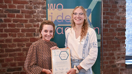 Two people holding a framed certificate.