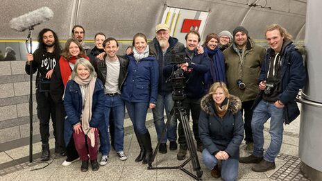 Group picture in a subway station with camera tripod and microphone angel