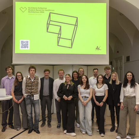 Winners of the Architects Collective Student Award for Healthcare Architecture on stage in front of a screen.